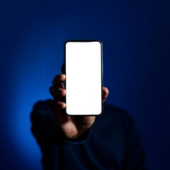 Smartphone Showcase: A person holds up a modern smartphone with a bright, blank screen, showcasing the device's sleek design against a vibrant blue background.
