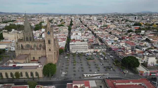 Aerial side movement across Guadalajara showing Templo Expiatorio, MUSA museum and university tower