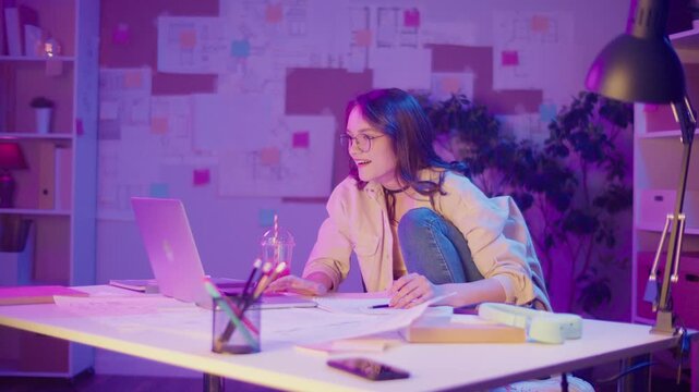 Empowered Learning, Academic Confidence, Digital Era. Student Sits in Relaxed Pose and Looks at Camera in Neon Room. A Portrait of Focus, Authenticity, and the New Face of Education