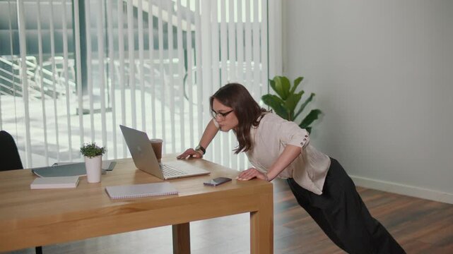 Wellness Routine. Female Professional Doing Desk Push Ups in Office, Promoting Daily Health Practices, Stress Relief, Employee Wellbeing, Corporate Fitness, and Balanced Work Life Productivity