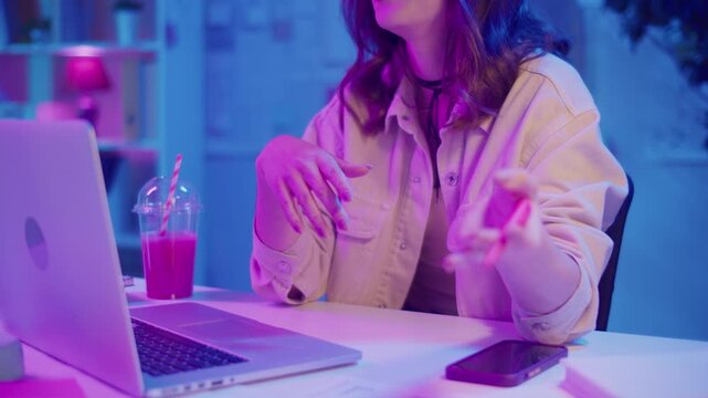 Virtual Leadership, Remote Work, Neon Aesthetic. Woman in Creative Neon Office Leads a Business Video Call. Confident Digital Presence in Informal Yet Professional Environment