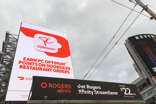 digital billboard advertisement for PC Optimum points card and Rogers Communications sign facing Sankofa Square, Toronto