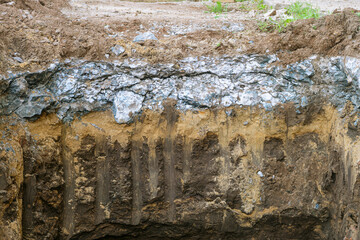 Cross-section of concrete road surface with underlying base layers on the ground