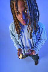 Young man with dreadlocks holding a gold bar, representing investment and prosperity