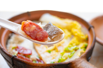 angle view clay pot rice of dried fish and Chinese sausage and vegetable at horizontal composition