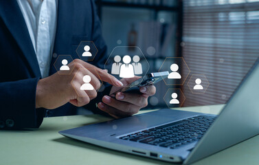 business professional using a smartphone and laptop for digital human resource management. Concept of recruitment, teamwork, leadership, HR technology, and online business communication.