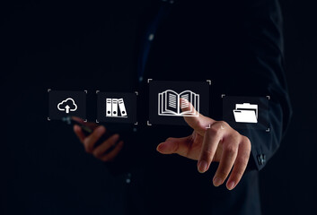 Businessman touching virtual icons of cloud, books, and folders. Concept of digital learning, online education, cloud data storage, knowledge management, e-learning technology for modern business.