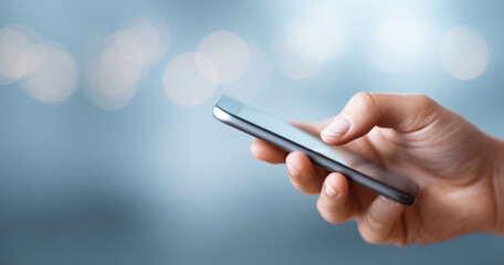A person's hand holding a smartphone with bokeh lights in the background