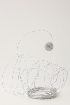 Entangled stainless steel wire and metal sponge installation against white background