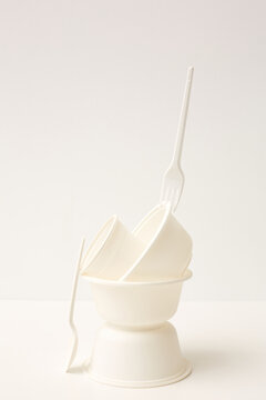 Three bowls, cup, fork and spoon white on white full shot composition