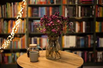 Cozy evening still life with flowers, teapot, cup of tea and copy space.