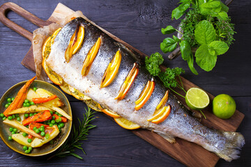 Whole roasted salmon on serving board. High angle view