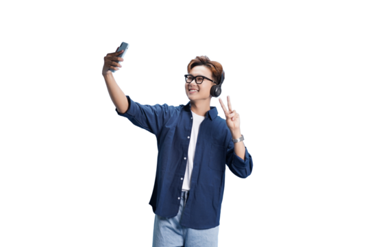 Selfie with Joy: A cheerful young man takes a selfie with a smile, showing a peace sign while wearing headphones. Capturing the essence of modern connection and youthful expression.