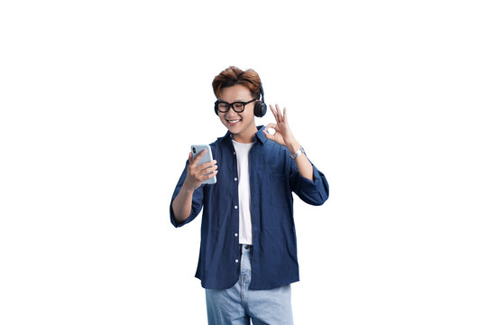 Music Enthusiast: An individual immersed in the world of music, donning headphones and holding a phone, radiating positive energy. He gives the okay gesture.