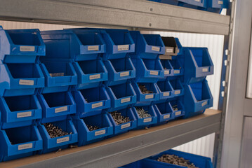 Industrial storage bins with metal screws in a warehouse shelf
