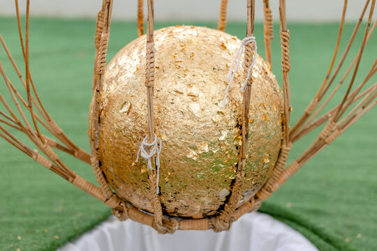 Luk Nimit, Golden consecration ball used in Thai temple ceremony, symbolizing Buddhist faith and Thai religious tradition