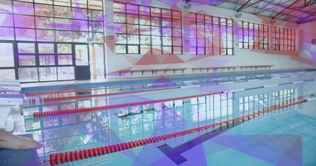 Empty lap pool reflecting steel-truss ceiling in aquatic center deck, with floating lane markers