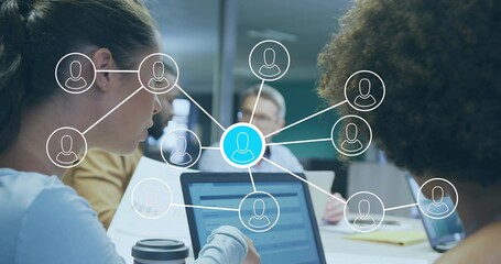 Collaborating four professionals using laptops in corporate conference room, with network overlay