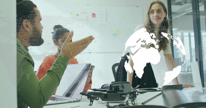 Team of four collaborating on strategy at conference table with drone and world map overlay - Powered by Adobe