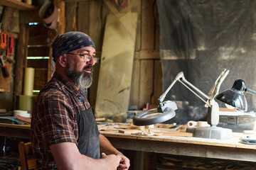 Craftsman in his workshop, artisan at work, handmade wood craft, woodworking hobby, natural light,...