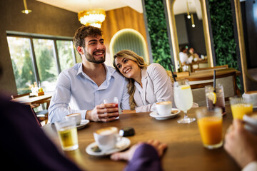 Couple hugging at restaurant with friends