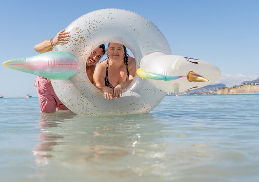 Friends enjoying at the beach with unicorn float