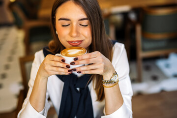 Young woman smiling with coffee in cozy cafe
