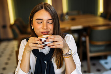 Young woman smiling with coffee in cozy cafe