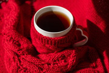 Festive Winter Moment with Knitted Mittens, Sweater, and Hot Drink