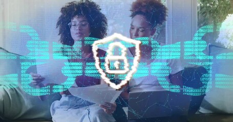 Two colleagues reviewing laptop with data overlay appearing glitch forming padlock securing data - Powered by Adobe