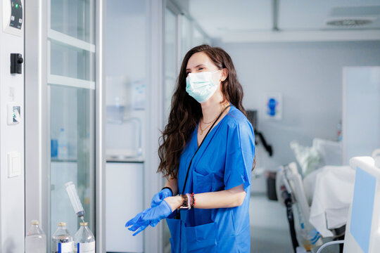 Nurse in ICU preparing for work with protective gear