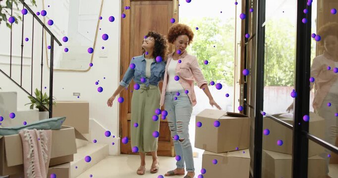 Friends entering foyer with boxes placing pillow taking tablet selfie with confetti revealing decor