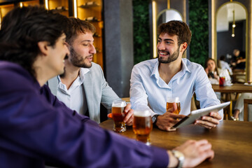 Colleagues discussing work over beer in restaurant