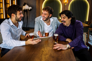 Colleagues discussing work over beer in restaurant