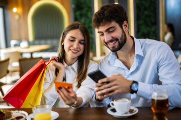 Couple shopping online in restaurant