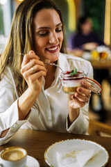 Woman eating cake in restaurant