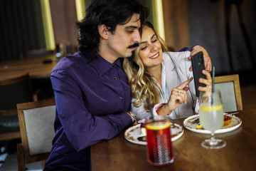 Couple checking phone over coffee and juice