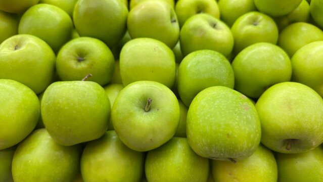 Fresh green apples piled together, perfect for healthy living, organic food themes, grocery ads, natural produce, and clean eating concepts. - Powered by Adobe
