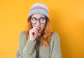 Frightened young woman biting fingernail and popped eyes at camera, being terrible accident,...