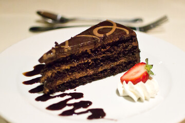 Slice of Chocolate Cake with strawberry and whipped cream.