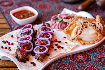Georgian kababi dish with garnishes and sauce