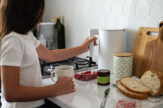 Preteen girl preparing breakfast with chocolate spread