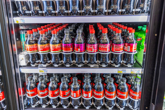 Coca Cola and Cherry Coke bottles neatly arranged on refrigerator shelves inside CVC store beverage section. Miami Beach. USA