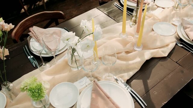 The wedding banquet tables are decorated with flowers and set with plates and glasses.