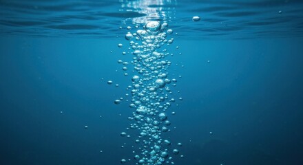 Obraz premium Bubbles ascend from the deep blue, breaking the surface of tranquil water