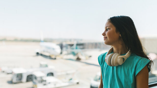 Young girl waiting at the airport with travel headphones
