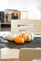 cozy fall dining scene with pumpkins, rustic kitchen setting featuring seasonal gourds and lace