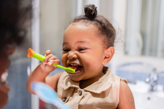 Mother and daughter brushing teeth together