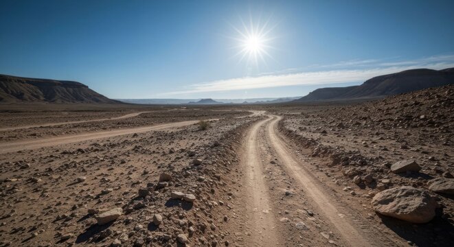 Dusty desert track winds through arid, sun-drenched valley towards distant mountains - Powered by Adobe
