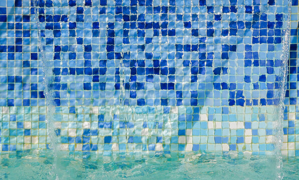 abstract blue mosaic tiles background of inside of fountain with reflection of sun light on water
